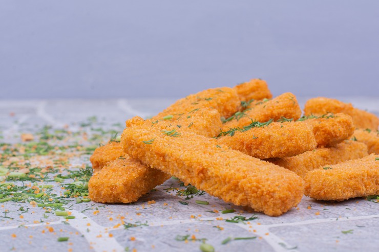 Bastoncini di pesce surgelati su carta da forno