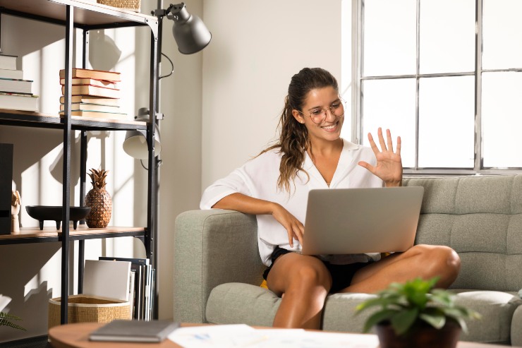 Una ragazza sul divano mentre lavora al pc