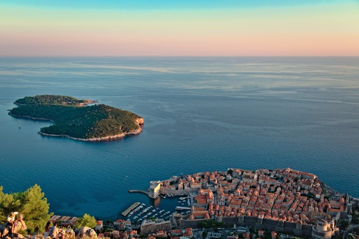 Vista di una città sul mare con un isola davanti 