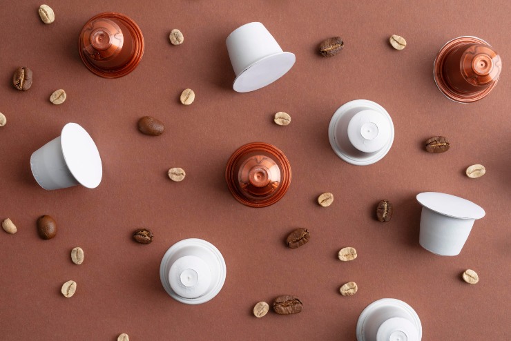 Caffè in capsule e chicchi di caffè su un tavolo 