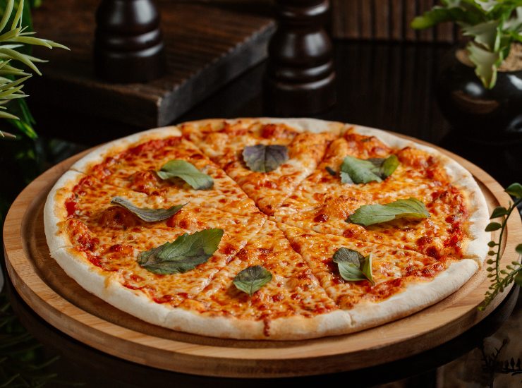 Una pizza margherita su un tagliere di legno