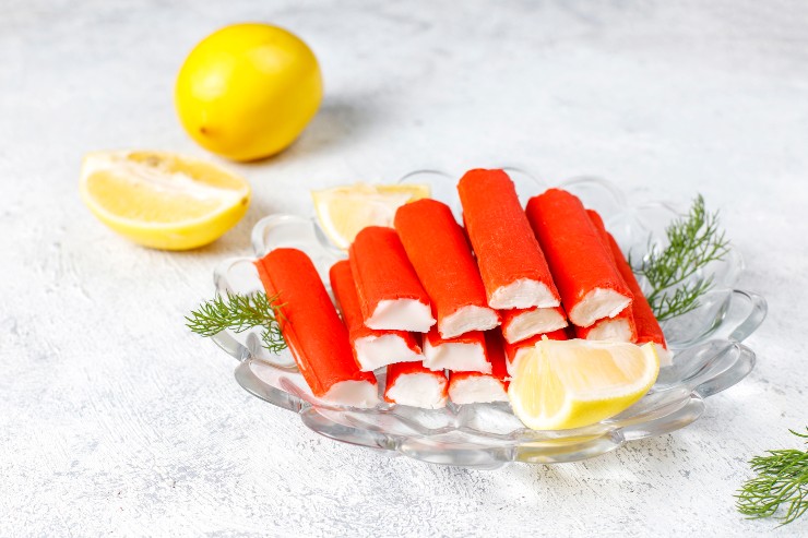 Surimi su un piatto di vetro davanti a un limone