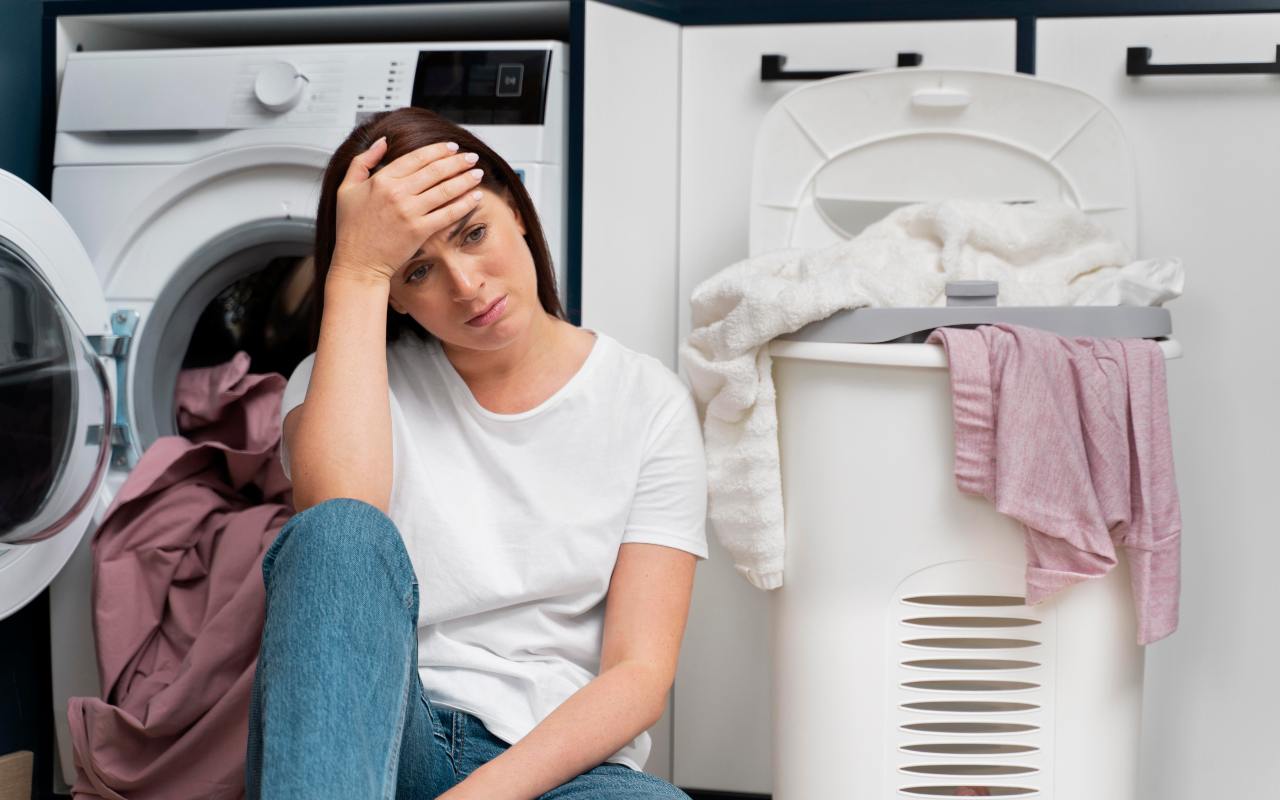 Una donna preoccupata davanti all'asciugatrice