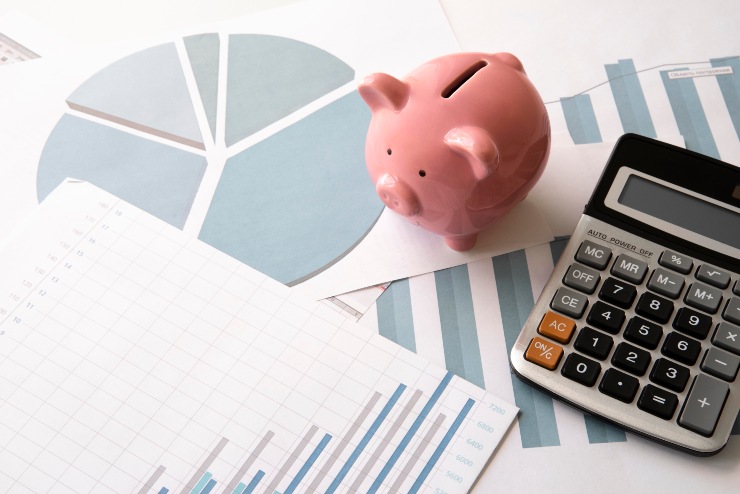 Concetto di obiettivi economici, con grafici e salvadanaio su un tavolo