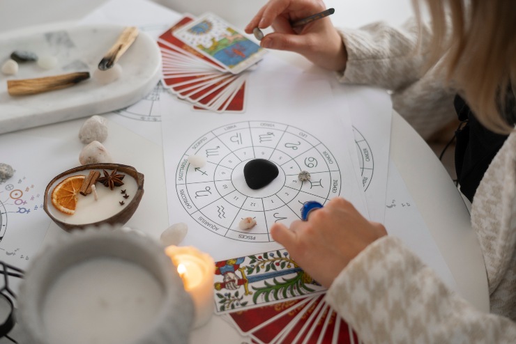Una ragazza prepara una mappa astrale con pietre e tarocchi