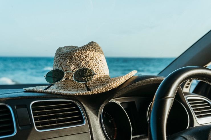 Cappello e occhiali da sole sul parabrezza di un'auto