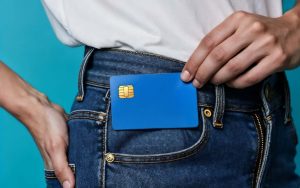 Una persona infila in tasca una carta prepagata