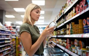 Una persona controlla l'etichetta di un prodotto al supermercato