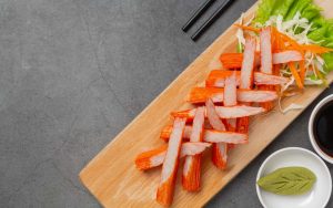 Surimi a fette su un piatto da portata in legno