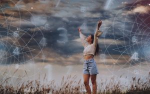 Una ragazza felice in un campo con numeri astrologici in cielo