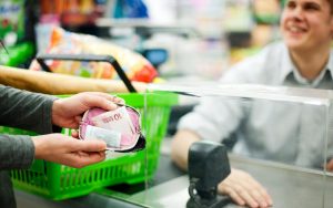 Una persona apre il portafogli per pagare la spesa alla cassa del supermercato
